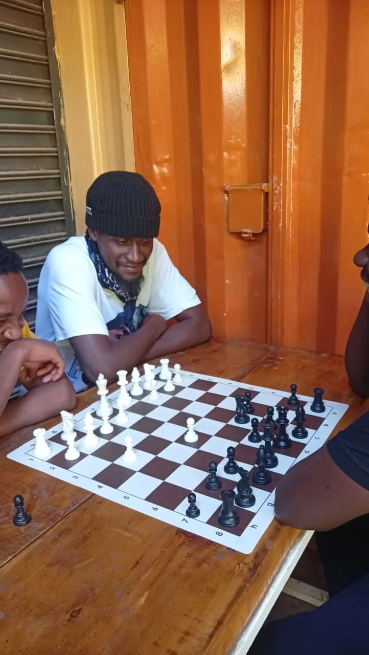Knight Life participants gathered around a chessboard during a tournament game